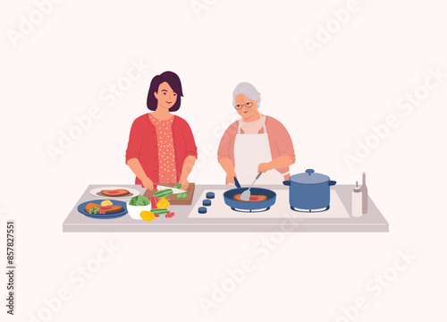 Smiling Elderly Mother In Apron Cooking Steak With Frying Pan. Adult Daughter Helping Her Mom To Cut The Cucumber. Half Length.
