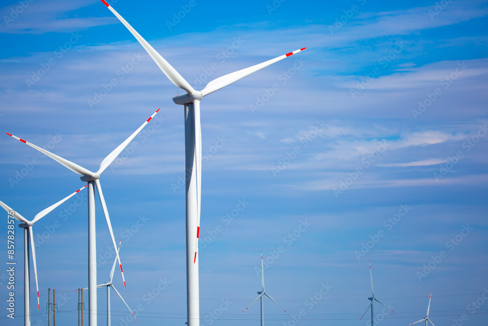 Fleet of power generators in motion. The blades of the wind farm rotate against the sky. The concept of extracting electricity from renewable sources. Wind turbine to generate electricity. Fleet of power generators in motion. The blades of the wind farm rotate against the sky. The concept of extracting electricity from renewable sources. Wind turbine to generate electricity.