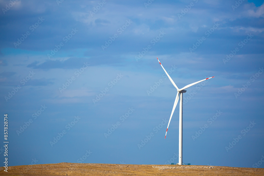 Fleet of power generators in motion. The blades of the wind farm rotate against the sky. The concept of extracting electricity from renewable sources. Wind turbine to generate electricity. Fleet of power generators in motion. The blades of the wind farm rotate against the sky. The concept of extracting electricity from renewable sources. Wind turbine to generate electricity.