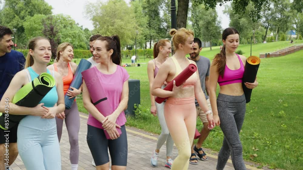 Group of people carrying yoga mats leaving outdoor yoga class in park. Concept of fitness, community, and well-being. Group of people carrying yoga mats leaving outdoor yoga class in park. Concept of fitness, community, and well-being.