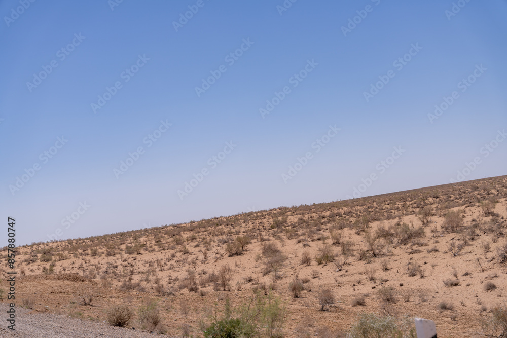 A vast, empty desert with a clear blue sky. The sky is so clear that it almost looks like a painting A vast, empty desert with a clear blue sky. The sky is so clear that it almost looks like a painting
