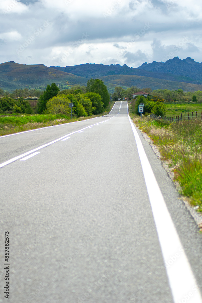 straight road into the mountains on a cloudy day straight road into the mountains on a cloudy day