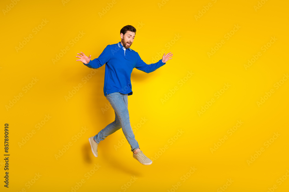 Full size photo of pretty young male running look down amazed wear trendy blue outfit isolated on yellow color background Full size photo of pretty young male running look down amazed wear trendy blue outfit isolated on yellow color background