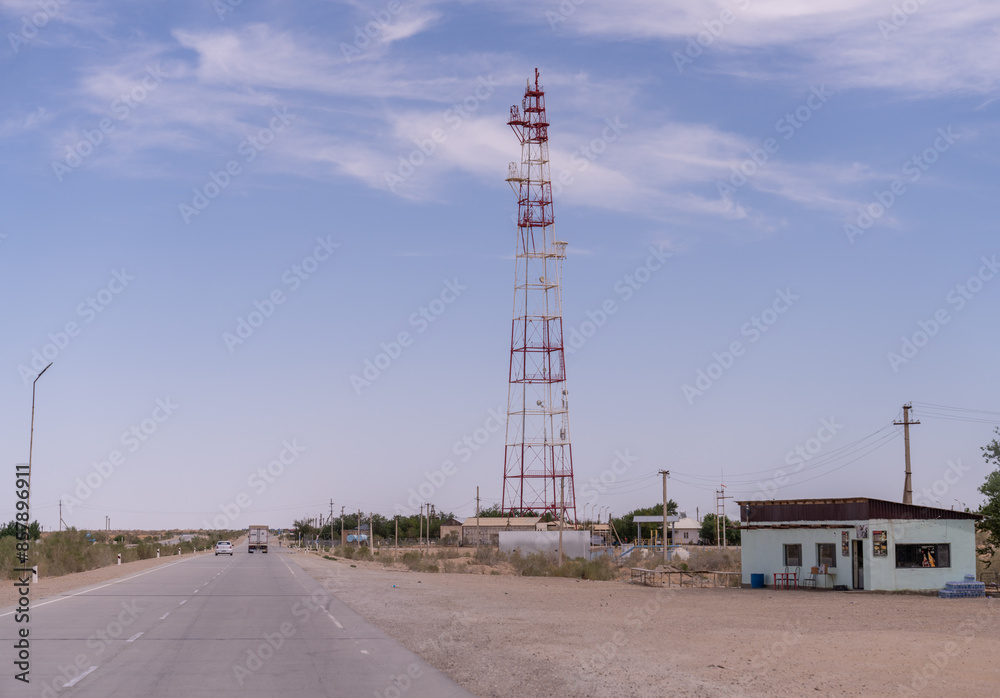 A tall tower is in the middle of a desert. The sky is clear and the sun is shining A tall tower is in the middle of a desert. The sky is clear and the sun is shining