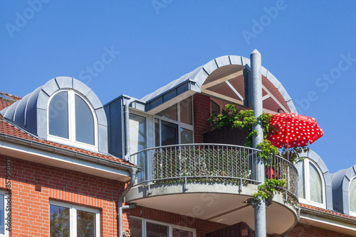 Modernes Wohngebäude aus Backsteinmit Balkon und Sonnenschirm,  Buxtehude, Niedersachsen, Deutschland photo