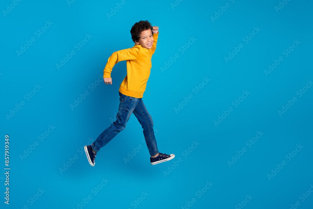 Fototapeta premium Full size photo of small charming boy running fast black friday wear trendy yellow outfit isolated on blue color background