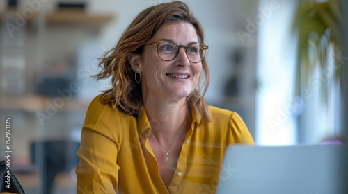 Smiling Woman Working on Laptop in Modern Office