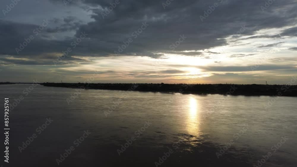 A calm river landscape at sunset with an orange sky reflecting on the water A calm river landscape at sunset with an orange sky reflecting on the water