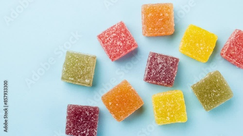 Stop motion of assorted jelly candies on blue background.