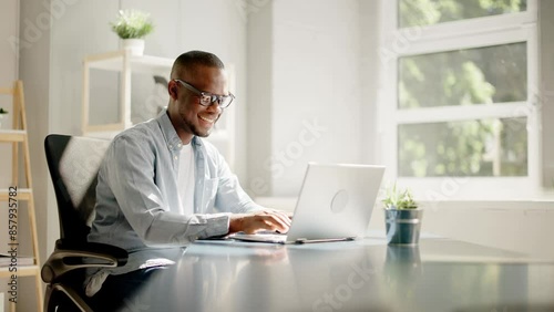 Smiling African American businessman using laptop and brainstorming strategy photo