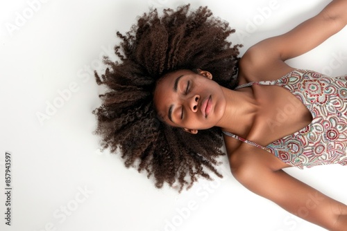 A woman is seen lying down on the ground with her hair flowing upwards, potentially indicating a moment of relaxation or distress photo