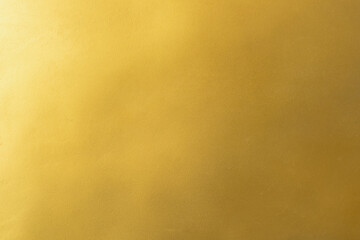 Gold wall texture background. Yellow shiny gold paint on concrete wall surface, vibrant golden luxury wallpaper, horizontal