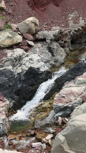 A beautiful river in a mountain gorge of the Himalayan mountains. A natural stream of a mountain river, with rocks full of minerals and flowers. photo