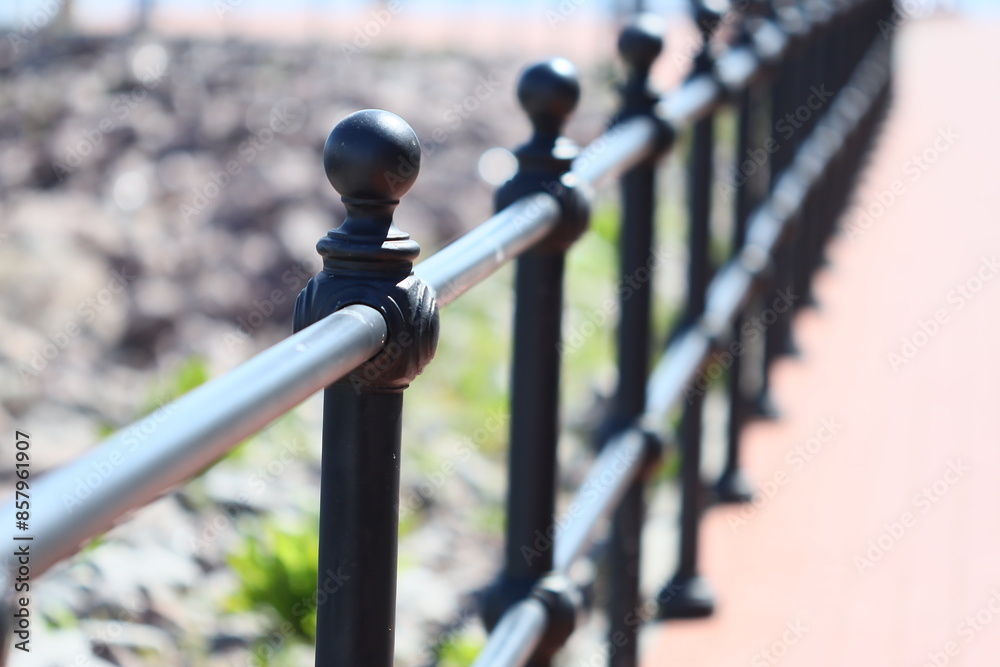 A close-up view of a metal fence on a sidewalk A close-up view of a metal fence on a sidewalk