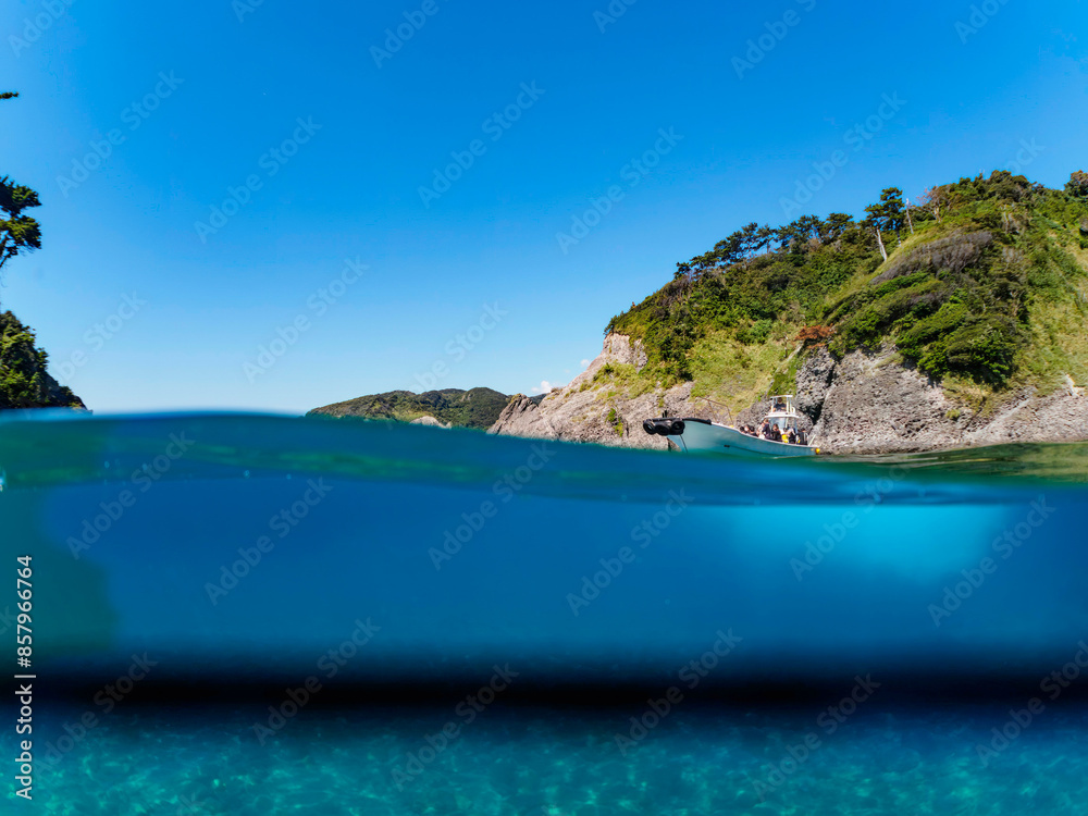 Fototapeta premium ヒリゾ浜渡船の漁船の美しい半水面撮影。日本国静岡県伊豆半島賀茂郡南伊豆町中木から渡し船で渡るヒリゾ浜にて。 2022年10月撮影。 