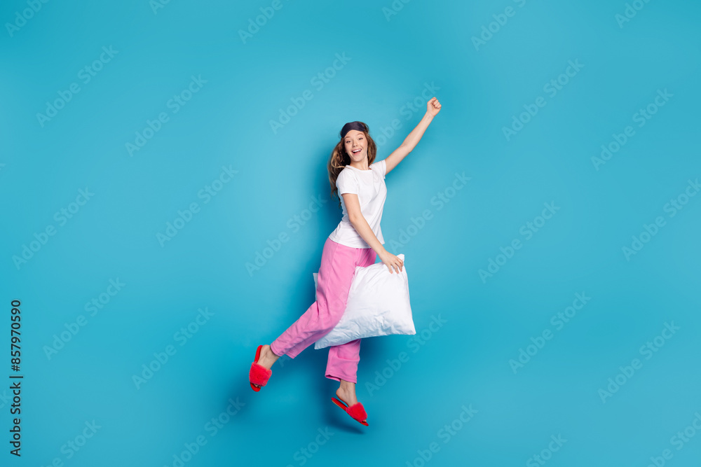 Fototapeta premium Photo of adorable positive cheerful girl wear stylish pajama raise hand fist isolated on blue color background