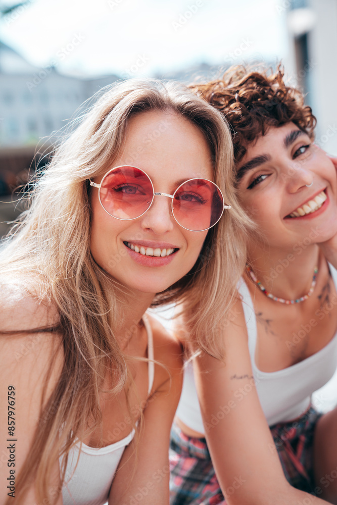 Two young beautiful smiling hipster female in trendy summer white t-shirt and shorts clothes. Sexy carefree women posing in the street. Positive models having fun, hugging and going crazy, sunglasses Two young beautiful smiling hipster female in trendy summer white t-shirt and shorts clothes. Sexy carefree women posing in the street. Positive models having fun, hugging and going crazy, sunglasses