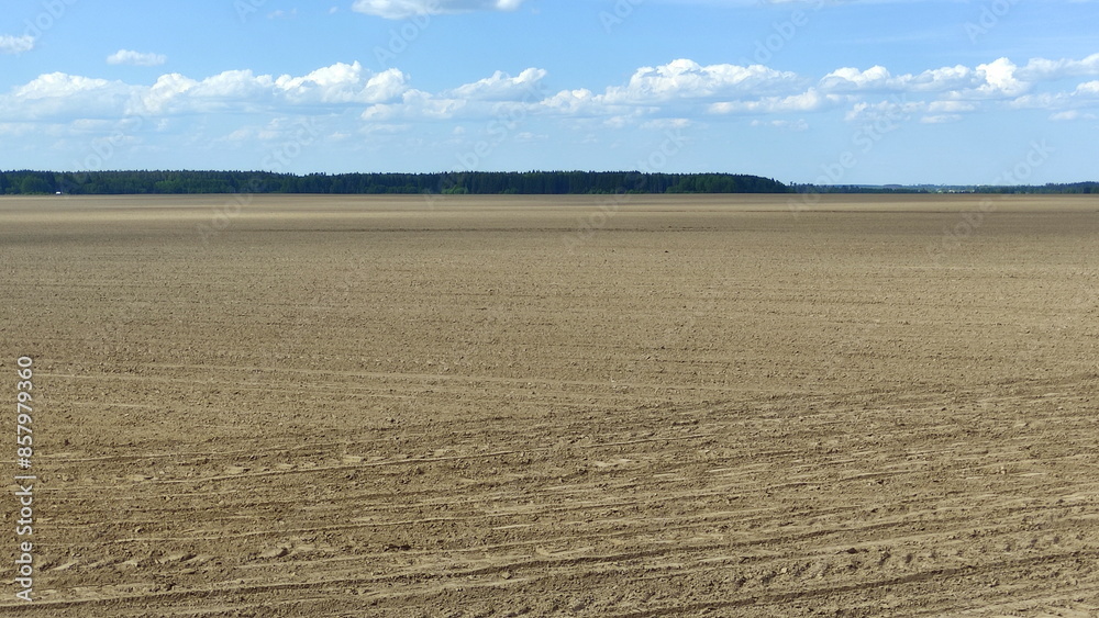 Cultivated plowed brown field at spring day. European agricultural farming landscape panorama Cultivated plowed brown field at spring day. European agricultural farming landscape panorama
