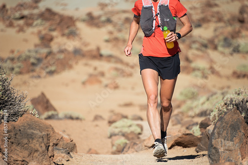 Female athlete run mountain race with hydratation trail vest for running photo