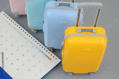 Planning travel trip and holidays and vacation concept. Many suitcases and calendar on gray background. 