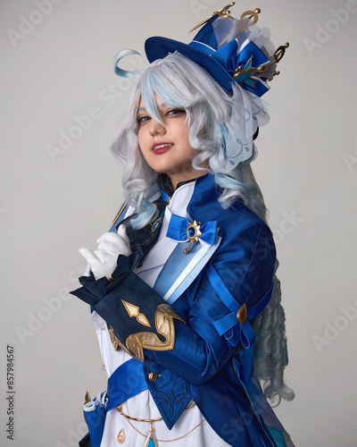 A girl in blue cosplay clothes and a wig and a crossbow poses in the studio on a light background