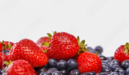A vibrant scattering of fresh, seasonal berries in a delightful mix of colors, glistening with sweetness. Ample space for your recipe or marketing message.