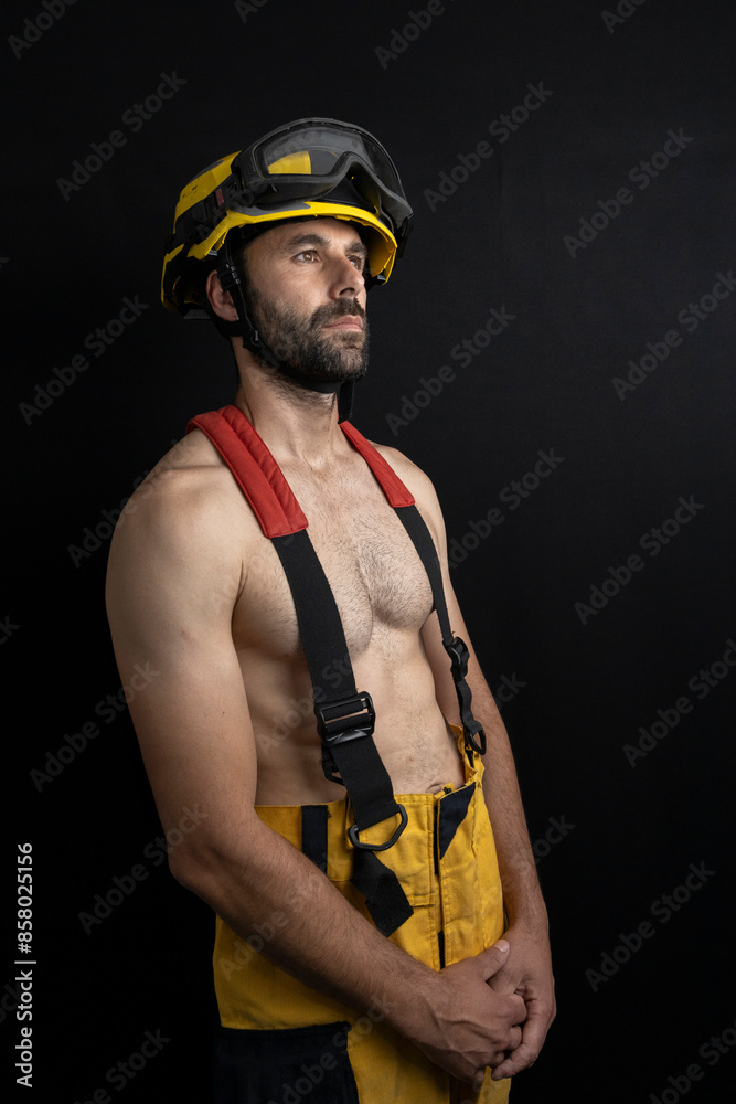 Fireman shirtless wearing helmet in a photo studio Fireman shirtless wearing helmet in a photo studio