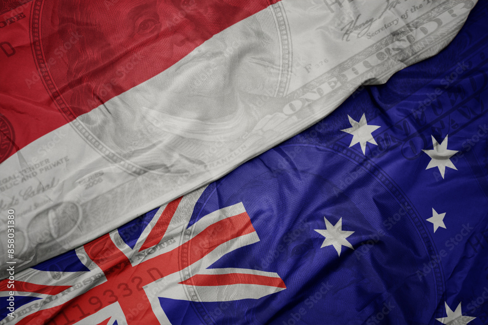 waving colorful flag of indonesia and national flag of australia on the dollar money background. finance concept. waving colorful flag of indonesia and national flag of australia on the dollar money background. finance concept.