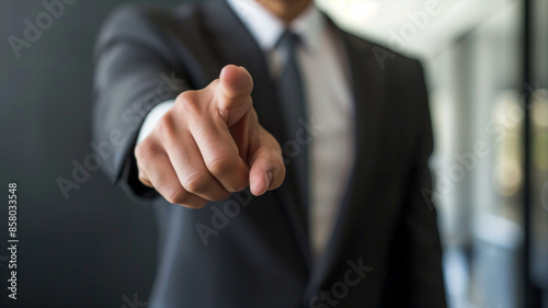Businessman in office pointing finger at viewer. Success, job candidate, and recruitment concept