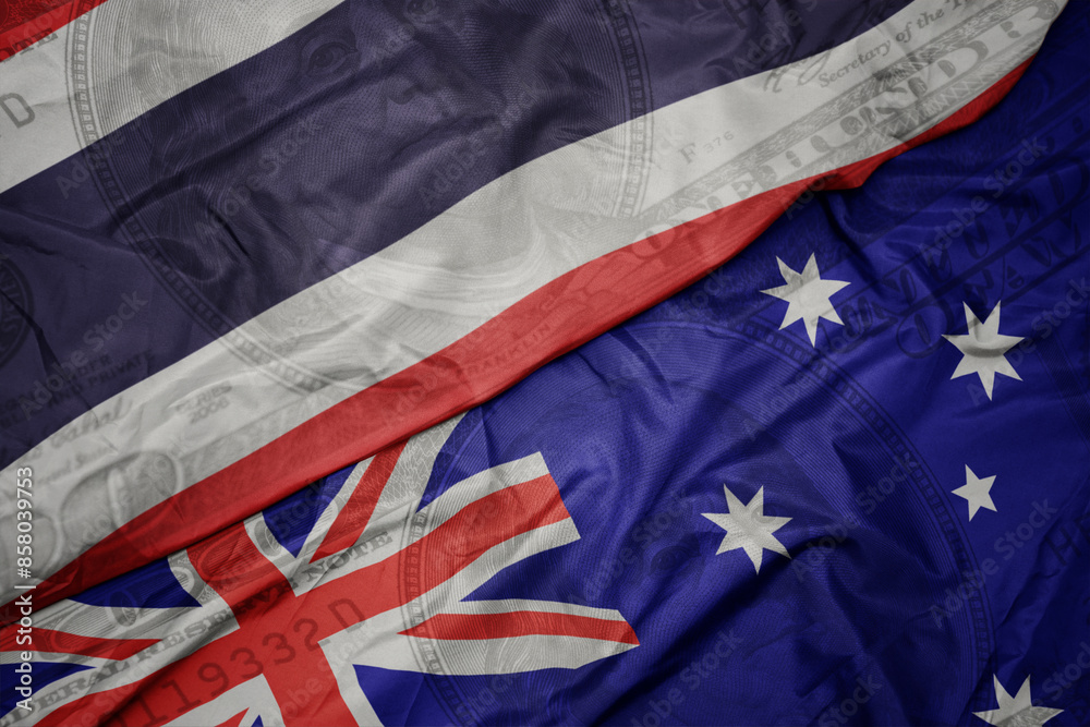 waving colorful flag of thailand and national flag of australia on the dollar money background. finance concept. waving colorful flag of thailand and national flag of australia on the dollar money background. finance concept.