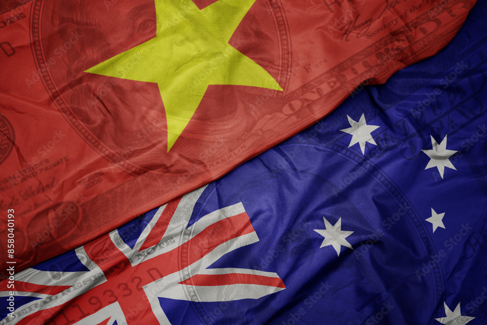 waving colorful flag of vietnam and national flag of australia on the dollar money background. finance concept. waving colorful flag of vietnam and national flag of australia on the dollar money background. finance concept.