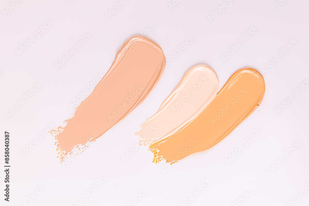 Three strokes of foundation powder of different tones on a white background. samples of the texture of the cosmetic product. Texture of foundation. Three strokes of foundation powder of different tones on a white background. samples of the texture of the cosmetic product. Texture of foundation.