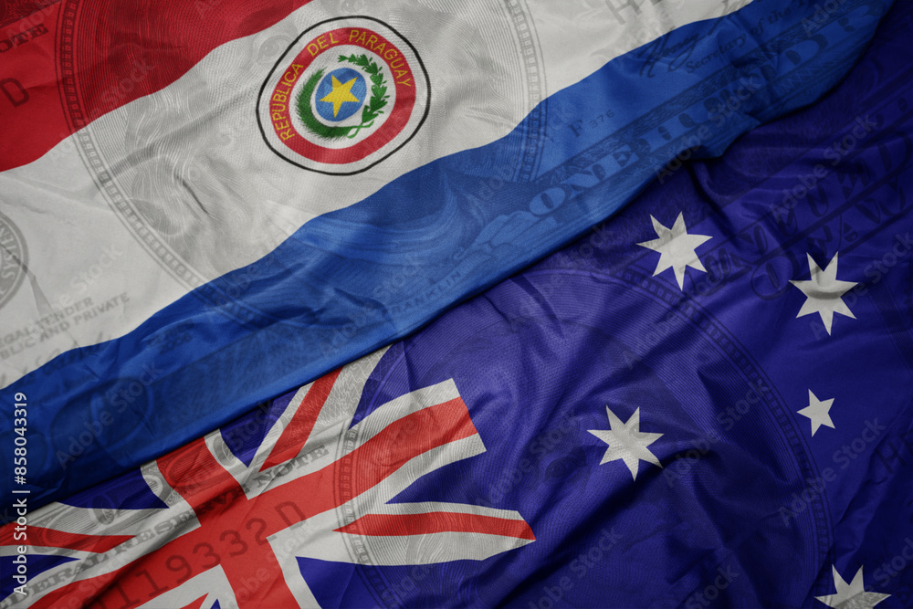 waving colorful flag of paraguay and national flag of australia on the dollar money background. finance concept. waving colorful flag of paraguay and national flag of australia on the dollar money background. finance concept.
