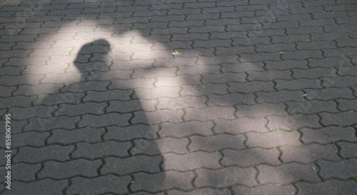 Surreal image formed by a shadow. Projection of shadow on the urban pavement creating a textured chiaroscuro effect.