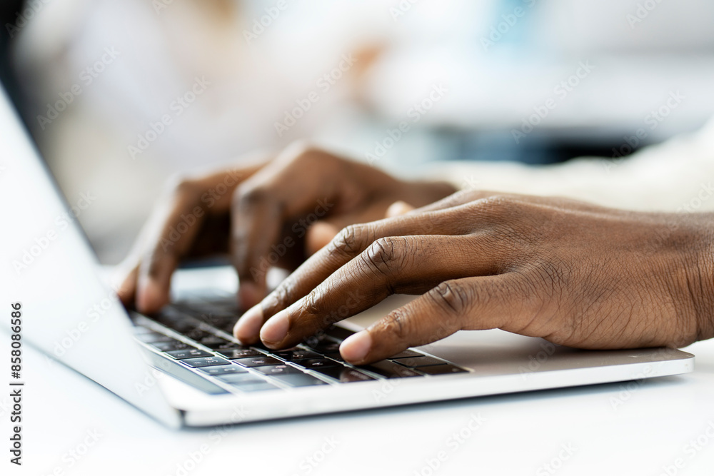 African American programmer writing code on laptop keyboard at workplace African American programmer writing code on laptop keyboard at workplace