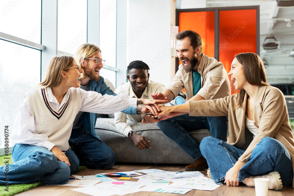 Excited multiethnic team celebrating success putting hands together