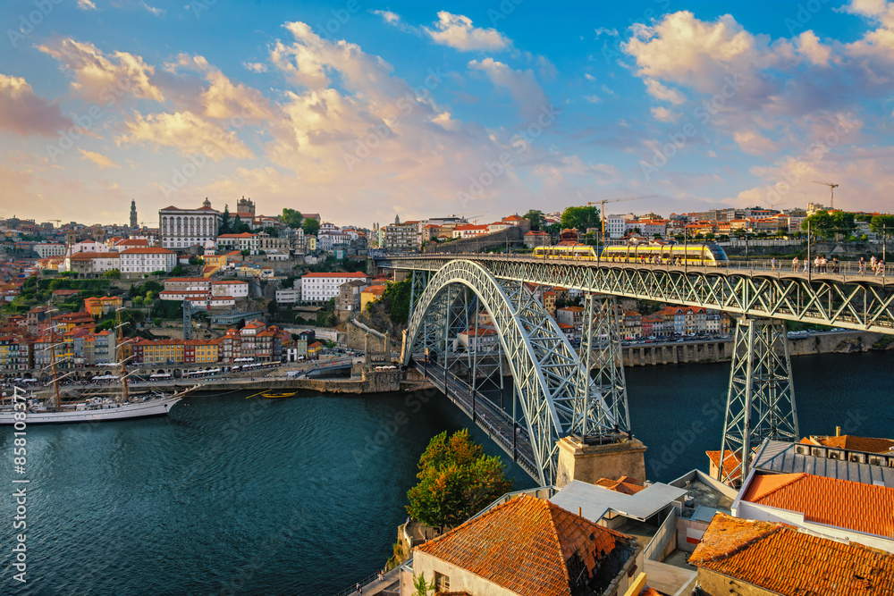 Obraz premium View of Porto city and Douro river and Dom Luis bridge I with tram from famous tourist viewpoint Miradouro do Jardim do Morro on sunset. Porto, Vila Nova de Gaia, Portugal