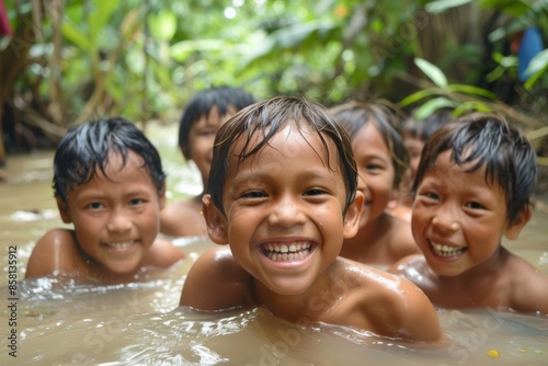 Happy children bathe in the water of a tropical river in Bali © Iigo