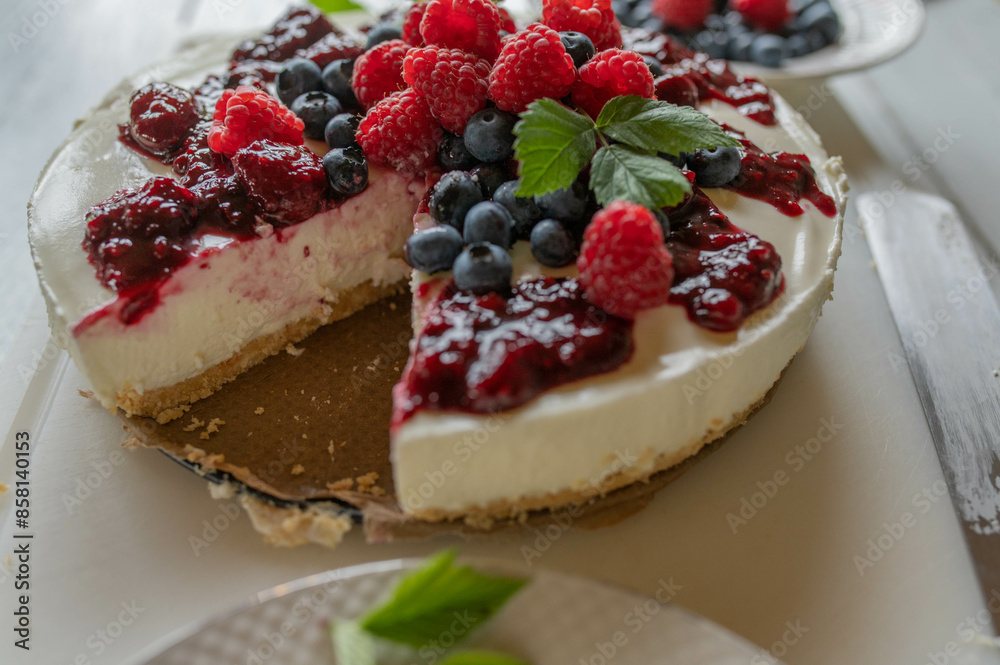 No bake cheesecake with fresh berries and berry compote on kitchen counter. Homemade summer cake No bake cheesecake with fresh berries and berry compote on kitchen counter. Homemade summer cake