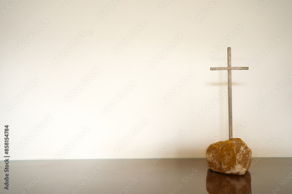 Naklejka premium Simple metal cross with wall background. Metal cross with space.