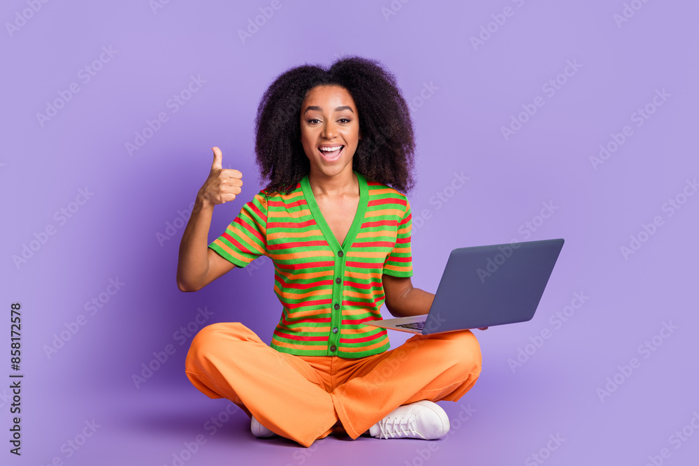 Full length photo of shiny attractive lady dressed striped cardigan working modern gadget thumb up isolated purple color background Full length photo of shiny attractive lady dressed striped cardigan working modern gadget thumb up isolated purple color background