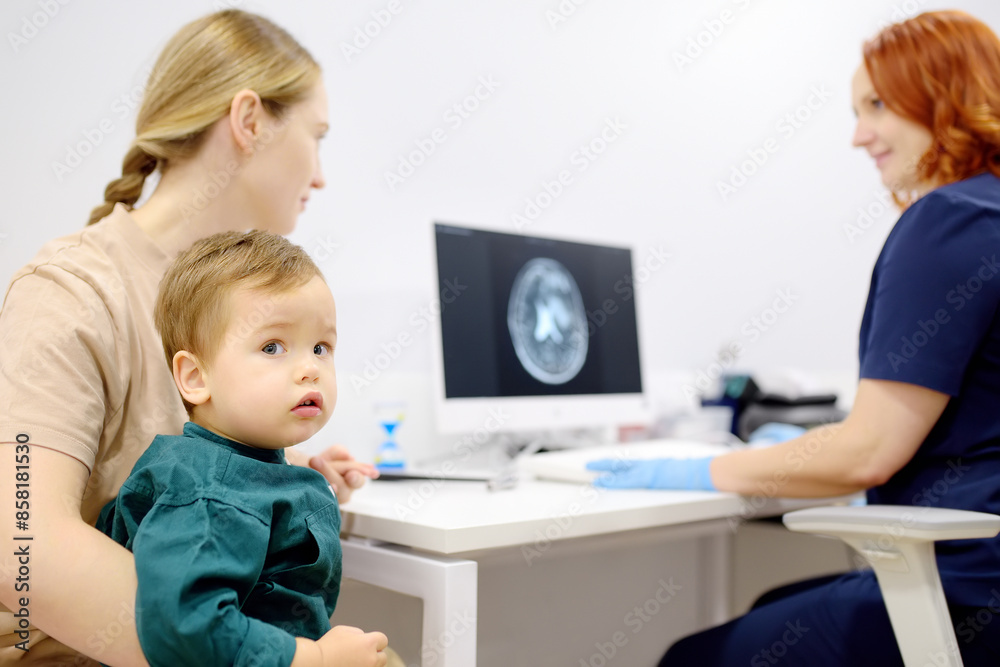 Toddler boy with his mom are at appointment with a pediatric neurologist. A mother tells an attentive doctor about her baby’s injury. Toddler boy with his mom are at appointment with a pediatric neurologist. A mother tells an attentive doctor about her baby’s injury.