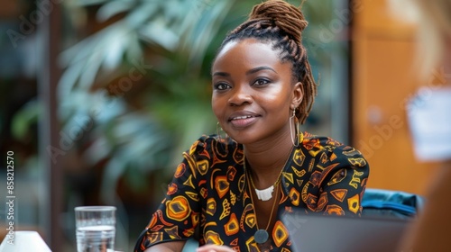 Confident and successful African businesswoman leading a team meeting discussing project details and strategy with her colleagues in a well appointed contemporary office environment photo