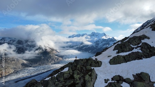 Tiny human standing in front of glacier in Switerland