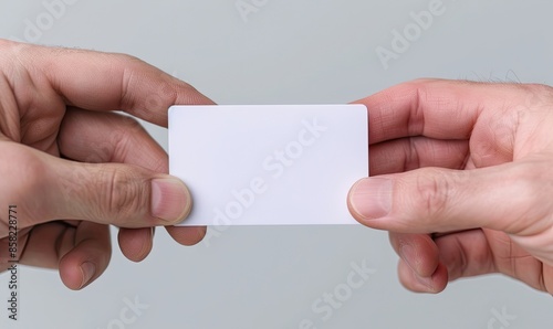 Two hands exchanging a blank business card, symbolizing business connections, networking, and professional relationships. photo