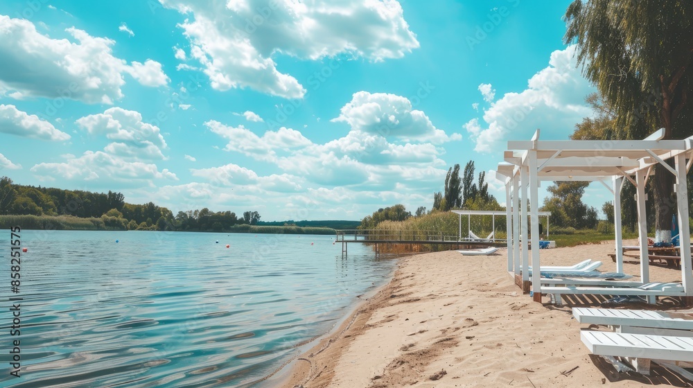 Obraz premium a beach area with canopies and a bed on the shore of a lake, featuring a sandy beach and a calm landscape, perfect for a summer vacation background.