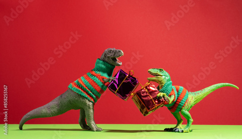 Fototapeta Naklejka Na Ścianę i Meble -  Cute dinosaurs give each other gifts on red and green background.