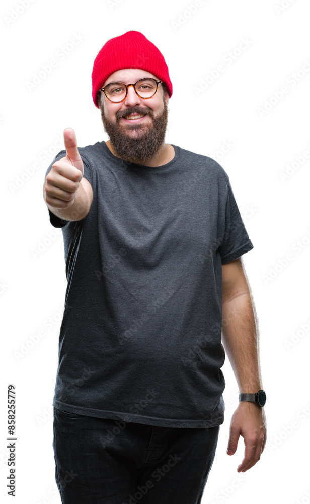Young caucasian hipster man wearing glasses over isolated background doing happy thumbs up gesture with hand. Approving expression looking at the camera with showing success. Young caucasian hipster man wearing glasses over isolated background doing happy thumbs up gesture with hand. Approving expression looking at the camera with showing success.