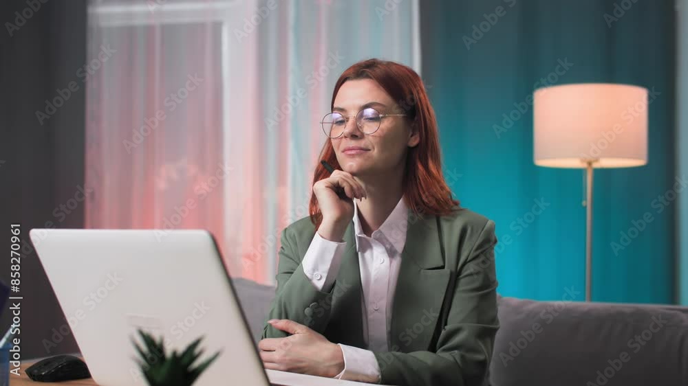 work from home, thoughtful young woman wearing glasses working on laptop and writing in notebook in home office work from home, thoughtful young woman wearing glasses working on laptop and writing in notebook in home office