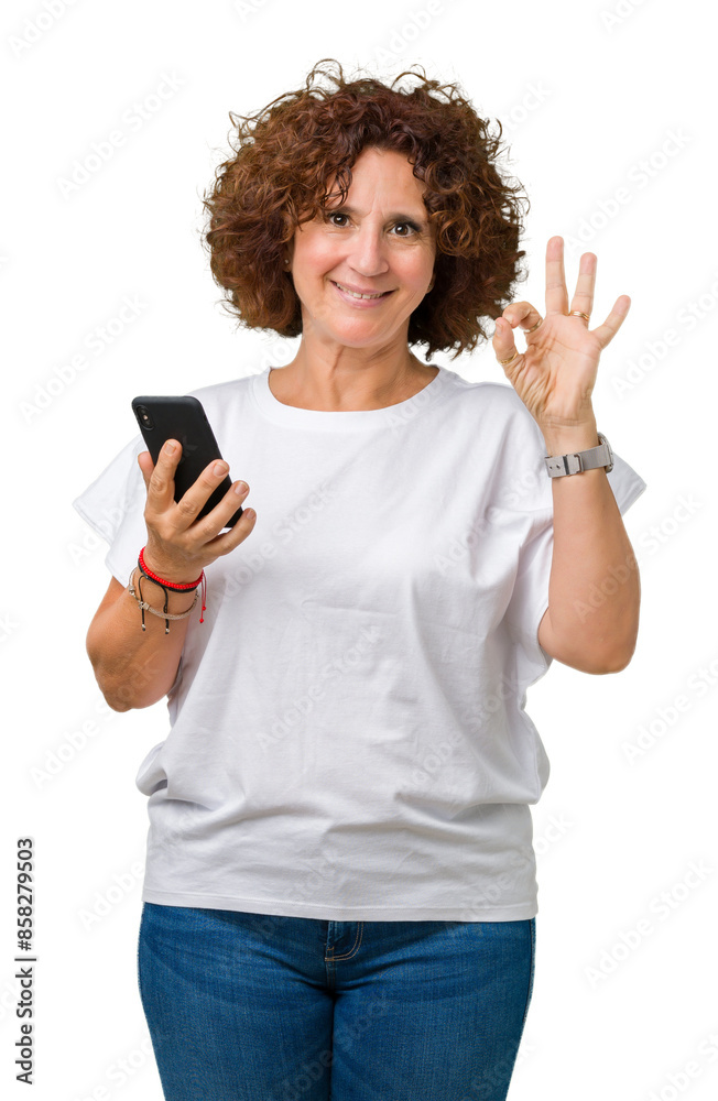Middle ager senior woman using and texting with smartphone over isolated background doing ok sign with fingers, excellent symbol